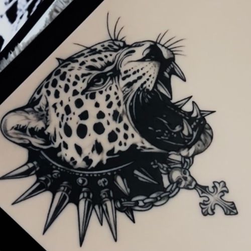 A snarling leopard in a spiked collar with a cross pendant, tattooed in bold blackwork on a TrueSkin sheet.
