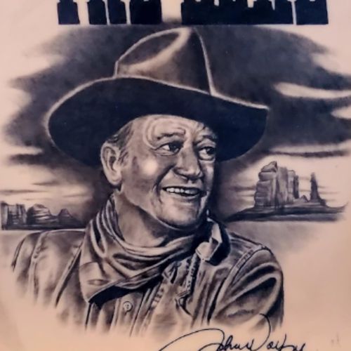 A black and grey portrait of a man in a cowboy hat against a desert landscape, tattooed on a TrueSkin sheet.
