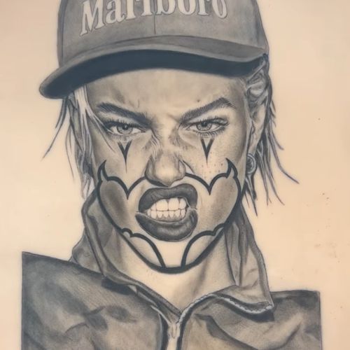 A portrait of a woman in a cap with clown-style face makeup, tattooed in heavy black and grey on a TrueSkin sheet.